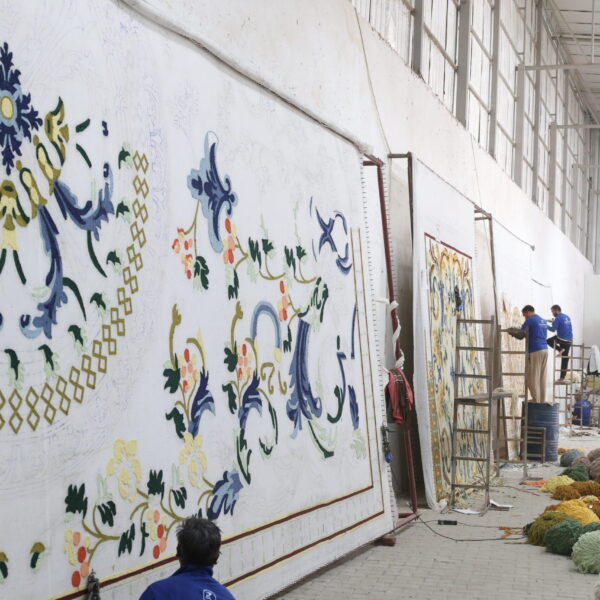 Skilled artisan hand-tufting a custom-designed carpet with precision and care at Ramsha Carpets