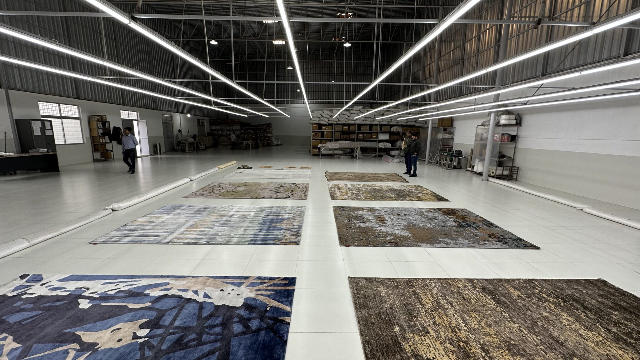 Large-scale carpets manufacturing hall with machinery and workers producing bulk customised carpets at Ramsha Carpets